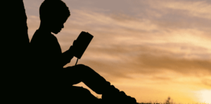 silhouette image of a boy reading