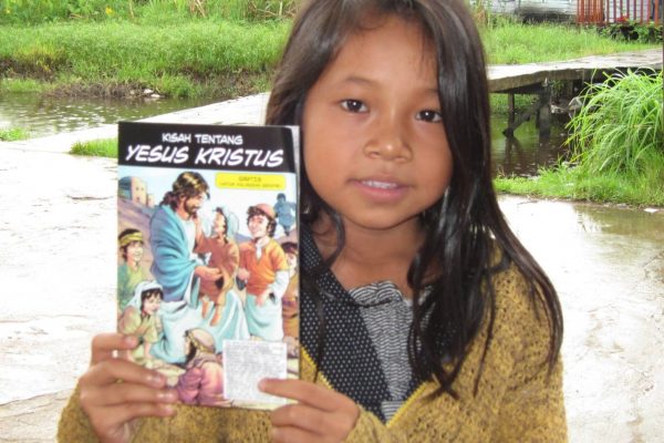 photo of little girl holding up the story of Jesus christ